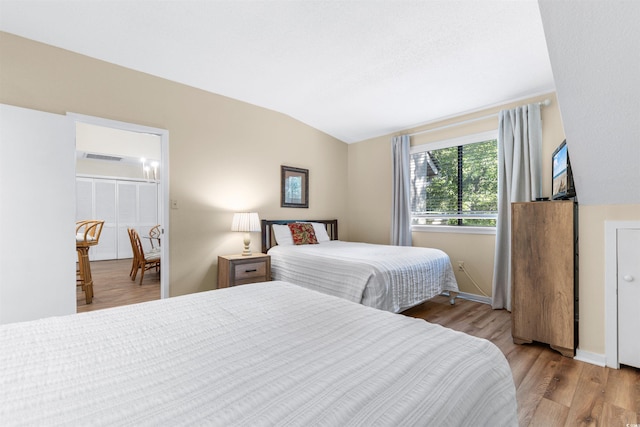 bedroom featuring light hardwood / wood-style flooring and vaulted ceiling