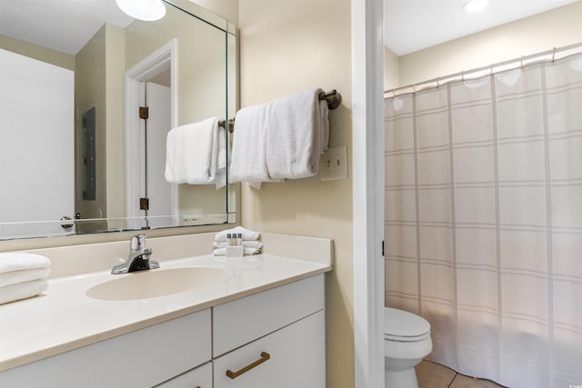 bathroom with tile patterned flooring, vanity, and toilet