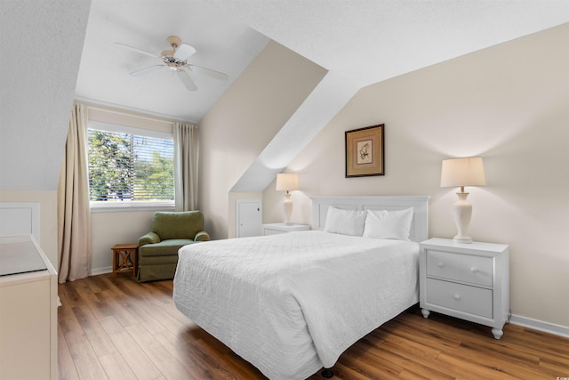 bedroom with dark wood-type flooring, ceiling fan, and lofted ceiling