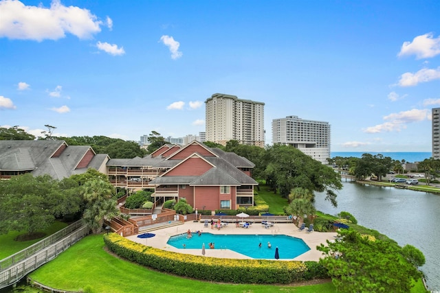 view of pool featuring a water view, a yard, and a patio