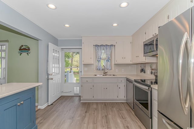 kitchen featuring white cabinetry, appliances with stainless steel finishes, sink, and light wood-type flooring