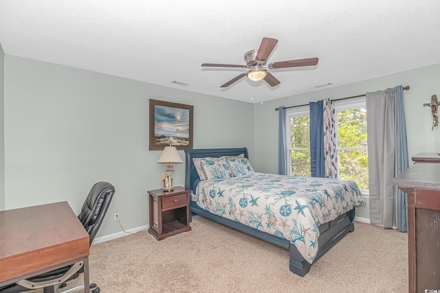 bedroom with a textured ceiling, ceiling fan, and carpet