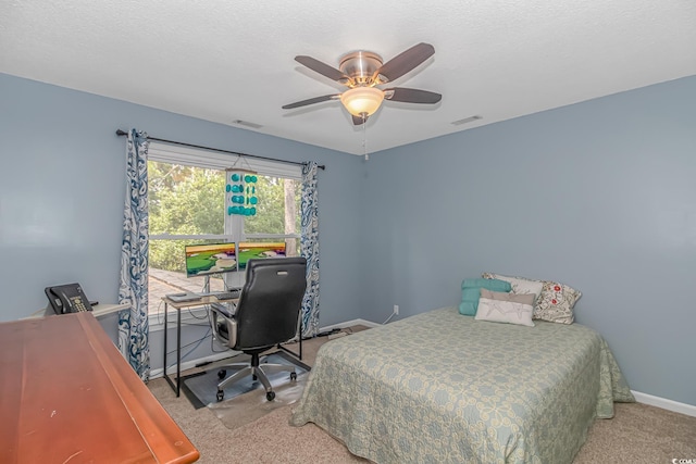 bedroom featuring light carpet, a textured ceiling, and ceiling fan