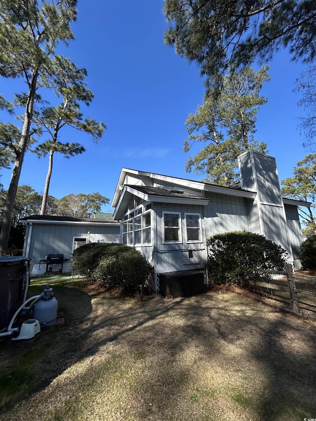 view of property exterior with a sunroom