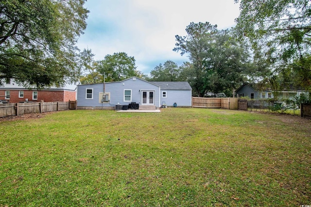 rear view of property with french doors, central AC, a patio area, and a lawn