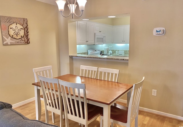 dining room with a chandelier and light wood-type flooring