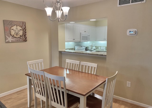 dining room featuring an inviting chandelier and light hardwood / wood-style floors