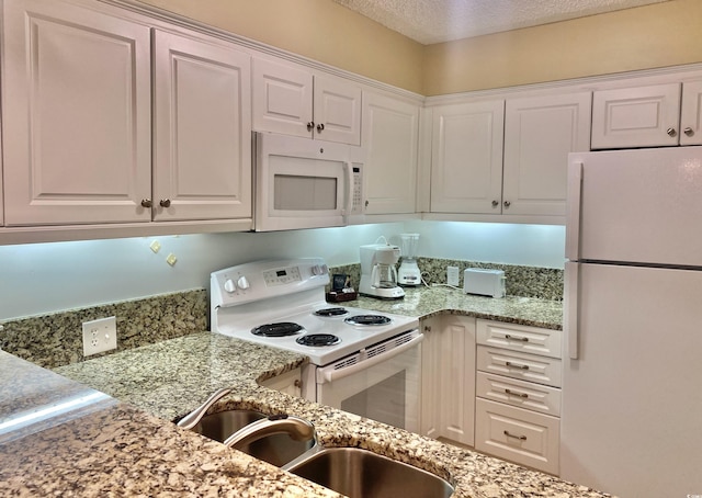 kitchen featuring white cabinetry, sink, a textured ceiling, and white appliances