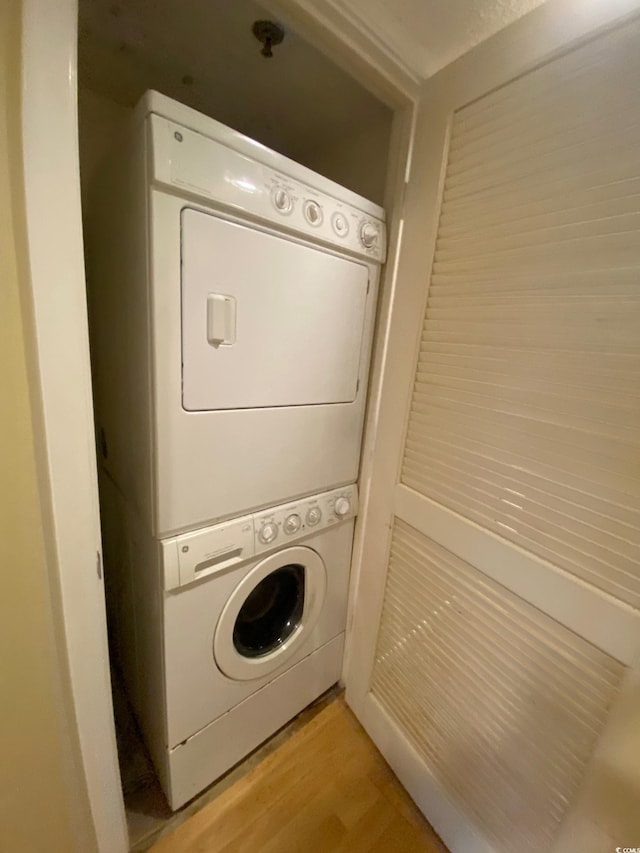 laundry area featuring light wood-type flooring and stacked washing maching and dryer