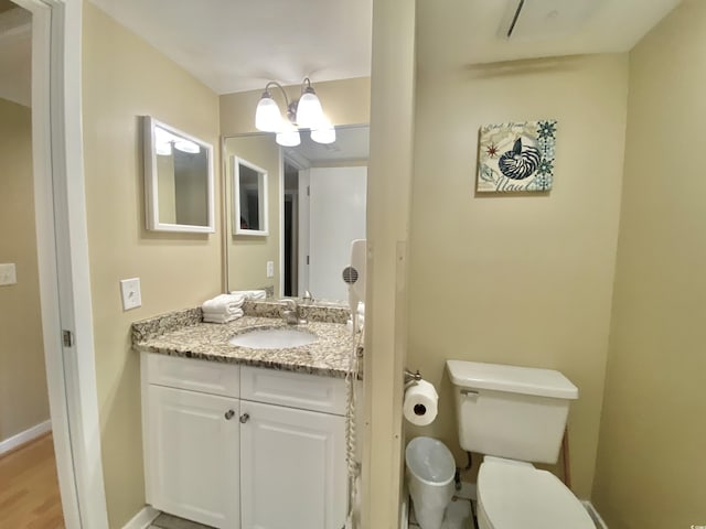 bathroom with vanity, toilet, and a chandelier