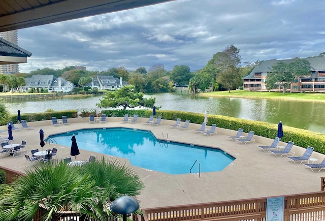 view of swimming pool with a patio and a water view