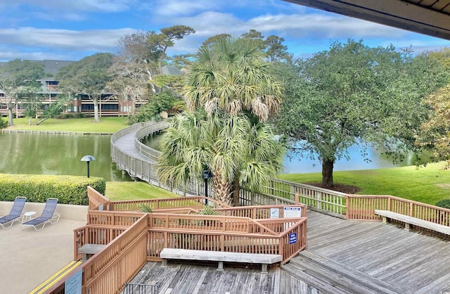 wooden deck with a yard and a water view