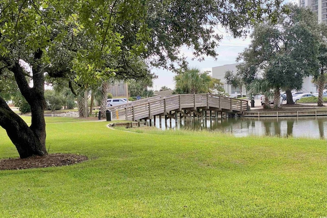 view of dock with a water view and a yard