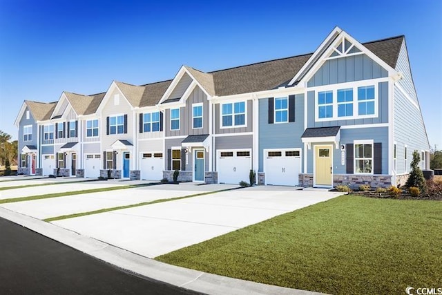 view of front facade with board and batten siding, a front yard, a garage, a residential view, and driveway