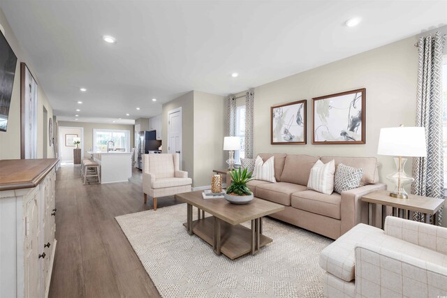 living area with recessed lighting, baseboards, and wood finished floors