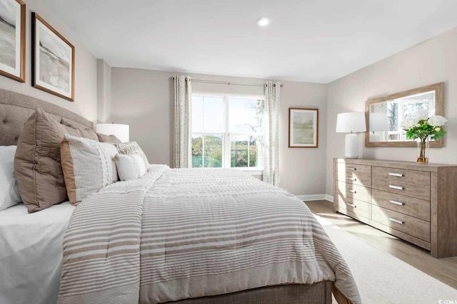 bedroom with light wood-type flooring and baseboards