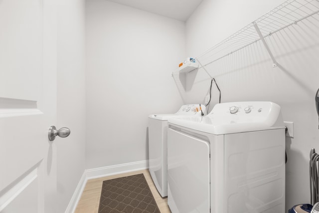 washroom with light hardwood / wood-style floors and washer and clothes dryer