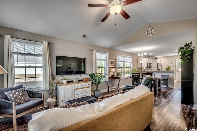 living room with ceiling fan with notable chandelier, hardwood / wood-style flooring, and lofted ceiling