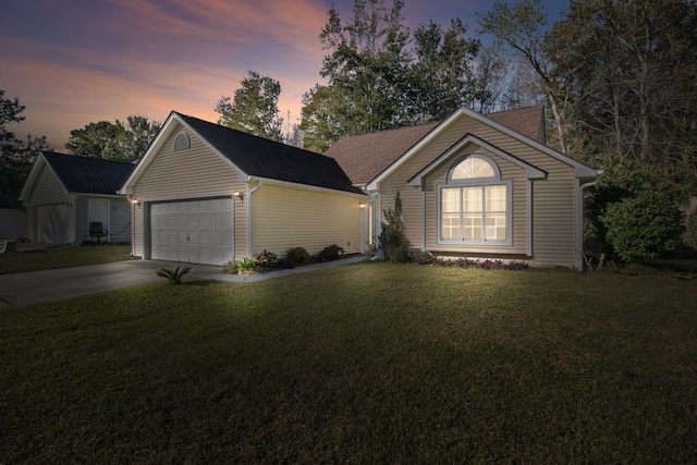 ranch-style house featuring a garage and a yard