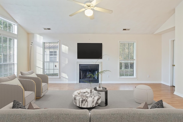 living room with light wood-type flooring, lofted ceiling, and ceiling fan