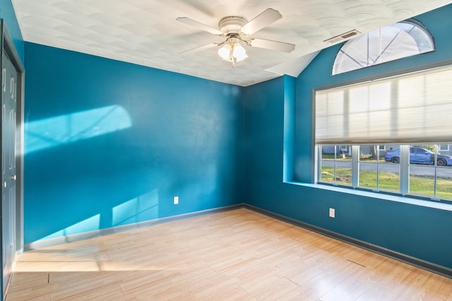 unfurnished room featuring light hardwood / wood-style floors, ceiling fan, and vaulted ceiling