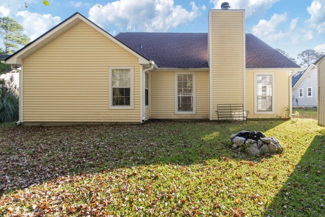 rear view of property with a lawn