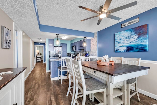 dining space featuring a textured ceiling, ceiling fan, and dark hardwood / wood-style flooring