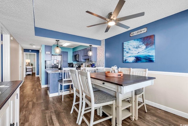 dining area with ceiling fan, a textured ceiling, and dark hardwood / wood-style floors