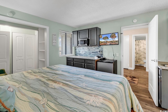 bedroom featuring a closet, a textured ceiling, and wood-type flooring