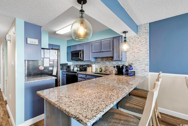 kitchen featuring kitchen peninsula, a textured ceiling, stainless steel appliances, and sink