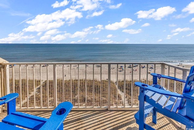 balcony with a water view and a beach view