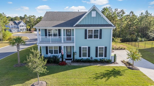 view of front of house featuring a balcony and a front lawn