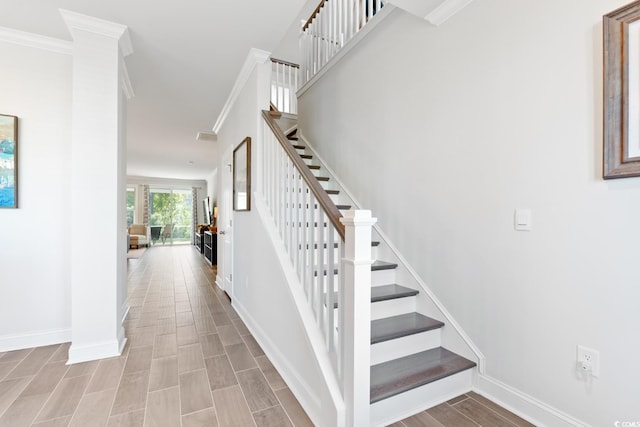 staircase with crown molding and wood-type flooring