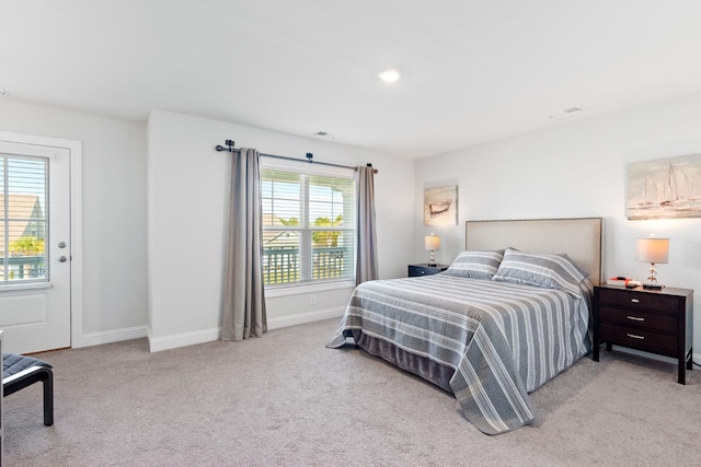 bedroom with multiple windows and light colored carpet