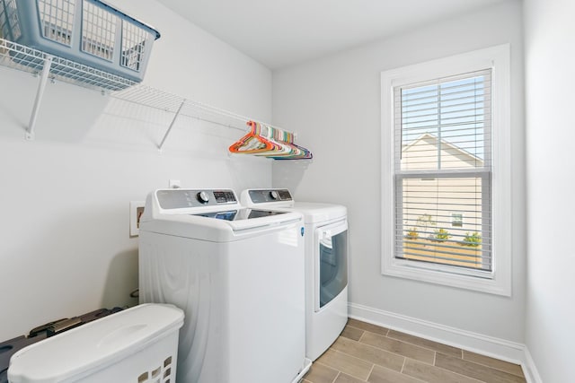 laundry room with washer and clothes dryer and light wood-type flooring