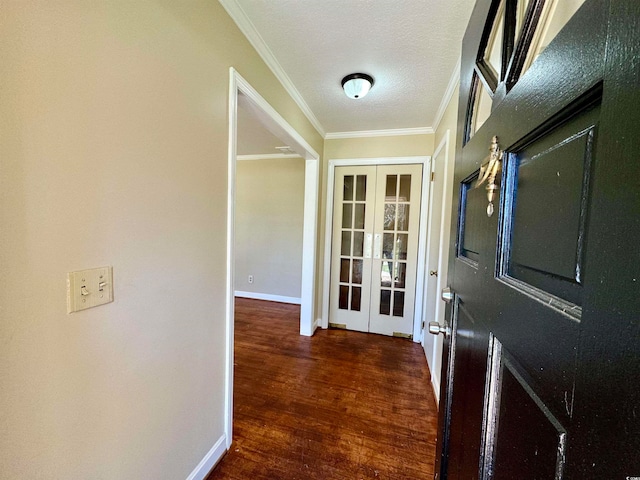 entryway featuring french doors, dark wood-type flooring, a textured ceiling, and ornamental molding