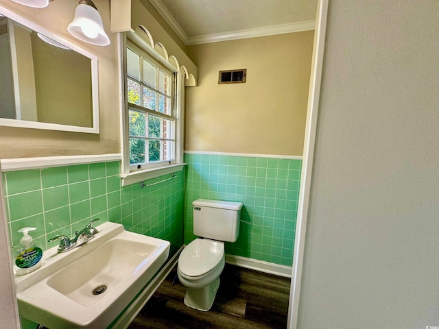 bathroom with sink, hardwood / wood-style flooring, toilet, tile walls, and crown molding