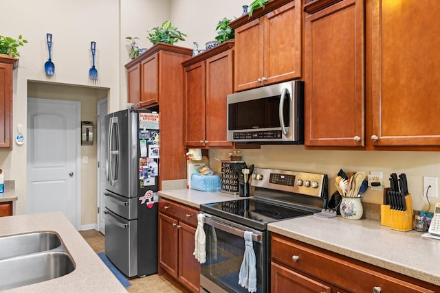 kitchen with sink, appliances with stainless steel finishes, and light tile patterned floors