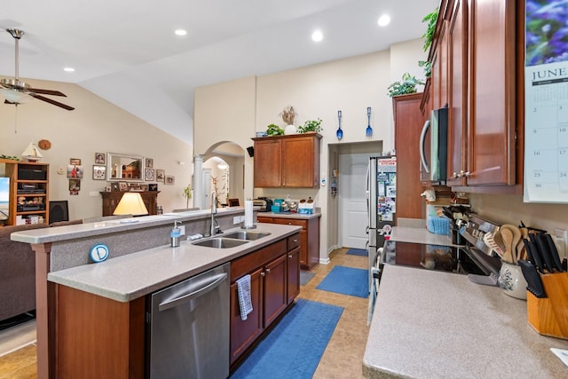 kitchen with appliances with stainless steel finishes, sink, ceiling fan, lofted ceiling, and a center island with sink