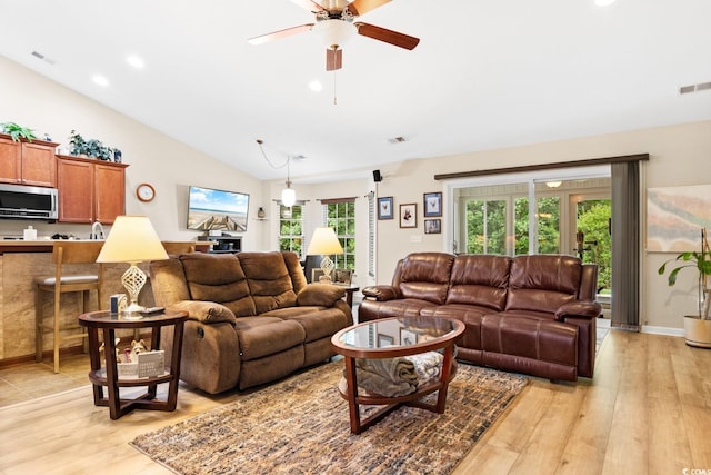 living room with lofted ceiling, light wood-type flooring, and ceiling fan