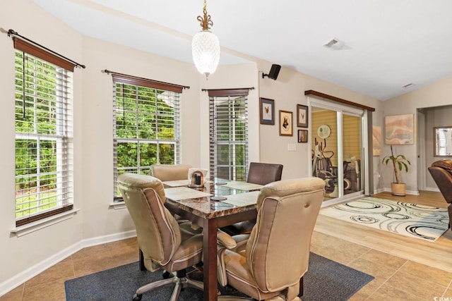 dining space featuring light hardwood / wood-style flooring, lofted ceiling, and a wealth of natural light