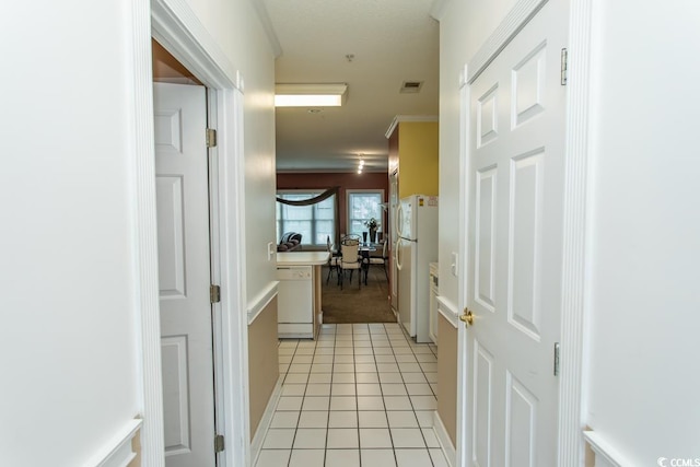 hall featuring crown molding and light tile patterned floors