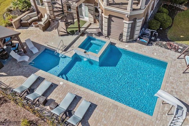 view of pool featuring a patio area and an in ground hot tub