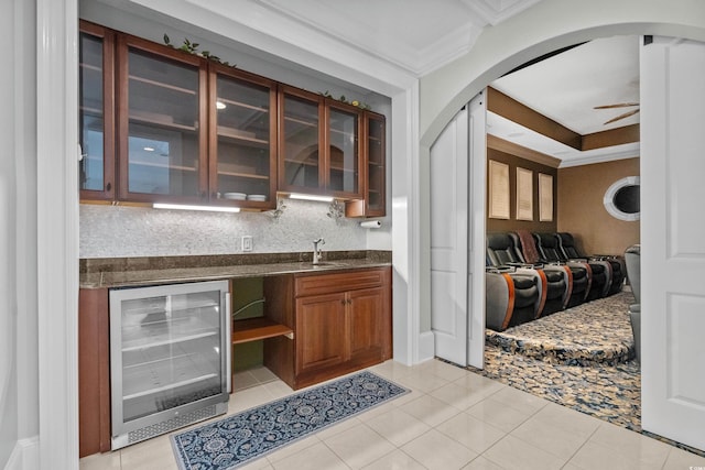 bar featuring ceiling fan, crown molding, sink, light tile patterned floors, and wine cooler