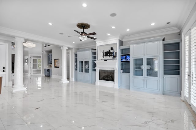 unfurnished living room featuring ornate columns, ornamental molding, built in shelves, a large fireplace, and ceiling fan