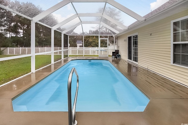 view of pool featuring a lawn, glass enclosure, and a patio