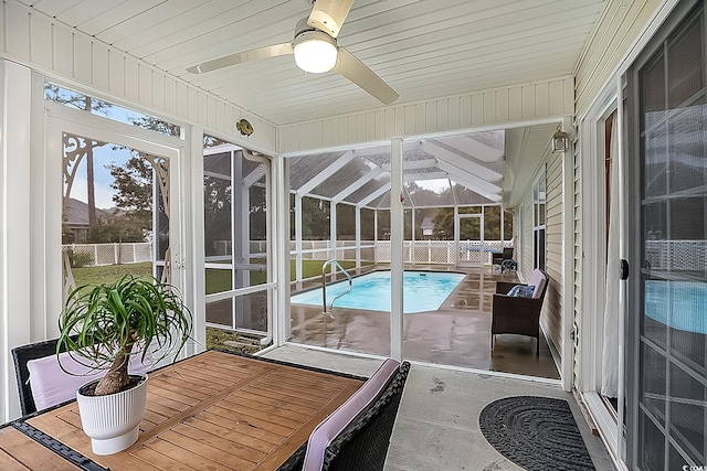 sunroom / solarium with ceiling fan, a hot tub, and vaulted ceiling