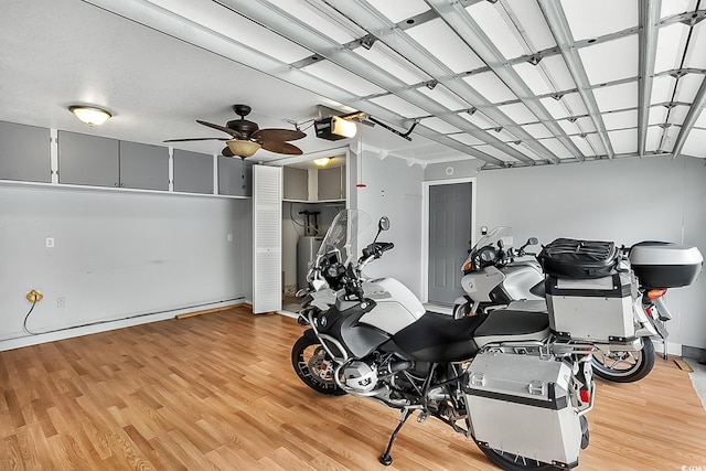 interior space featuring hardwood / wood-style flooring, ceiling fan, and gas water heater