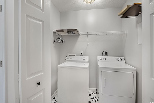 clothes washing area featuring a textured ceiling, tile patterned floors, and separate washer and dryer