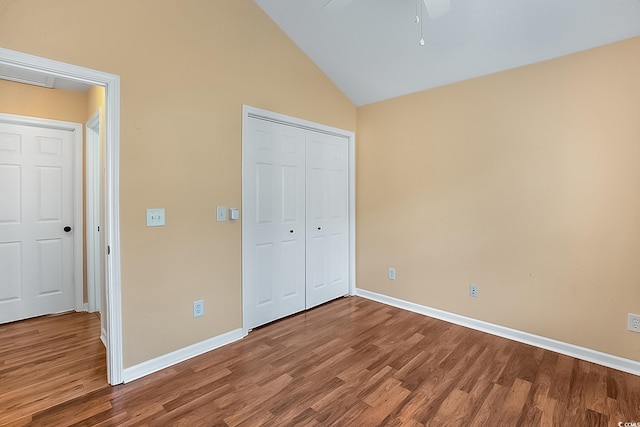 unfurnished bedroom featuring hardwood / wood-style floors, lofted ceiling, ceiling fan, and a closet